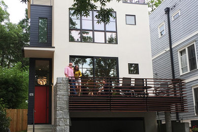 This is an example of a small modern three-storey stucco white house exterior in Atlanta with a flat roof and a tile roof.