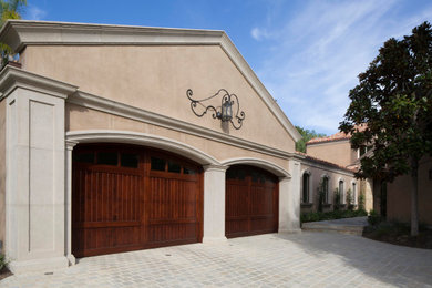 Example of a mid-sized tuscan attached two-car garage design in Los Angeles
