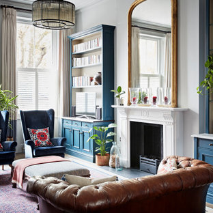 Großes Klassisches Wohnzimmer mit grauer Wandfarbe, dunklem Holzboden, Kamin, Kaminumrandung aus Stein, Eck-TV und braunem Boden in London