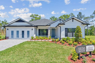 Inspiration for a mid-sized coastal white one-story concrete fiberboard and clapboard exterior home remodel in Jacksonville with a shingle roof and a black roof