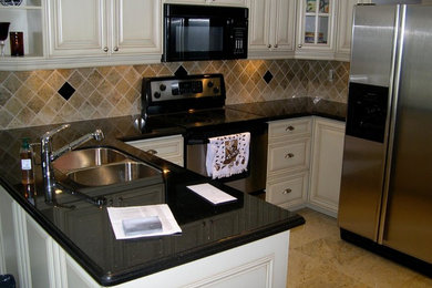 Inspiration for a mid-sized transitional u-shaped ceramic tile kitchen remodel in Toronto with a double-bowl sink, raised-panel cabinets, white cabinets, stone tile backsplash, stainless steel appliances and a peninsula
