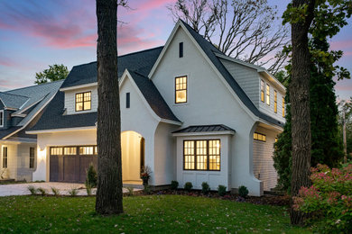 Large traditional white two-story stucco house exterior idea in Minneapolis with a shingle roof and a black roof