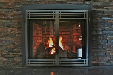 Living room - traditional living room idea in Calgary with a standard fireplace and a stone fireplace