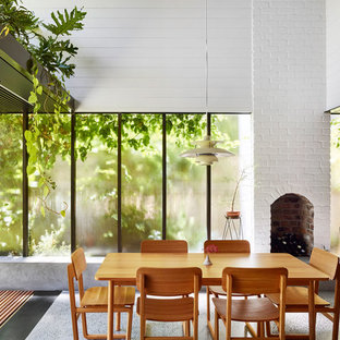 ブリスベンの中サイズのコンテンポラリースタイルのLDKの画像 (白い壁、コンクリートの床、標準型暖炉、レンガの暖炉まわり、グレーの床)