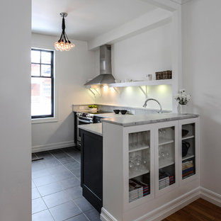 Small transitional kitchen pantry ideas - Example of a small transitional l-shaped porcelain floor kitchen pantry design in Ottawa with an undermount sink, shaker cabinets, black cabinets, marble countertops, white backsplash, stone slab backsplash, stainless steel appliances and a peninsula