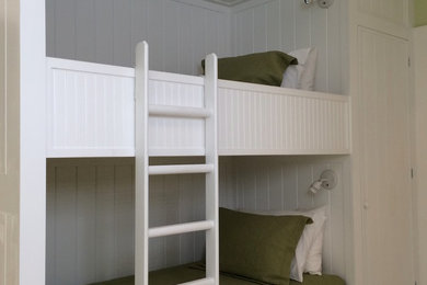 Mid-sized beach style guest light wood floor bedroom photo in New York with white walls
