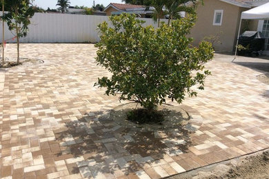 Large mediterranean backyard full sun formal garden in Miami with natural stone pavers.