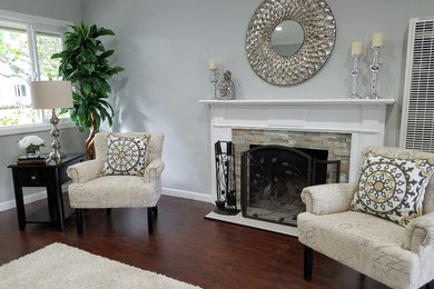 This is an example of a mid-sized traditional formal open concept living room in San Francisco with grey walls, dark hardwood floors, a standard fireplace, a stone fireplace surround, no tv and brown floor.