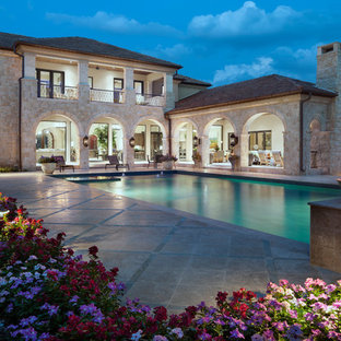 Zweistöckiges Mediterranes Haus mit Steinfassade in Austin