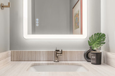 Powder room - small contemporary powder room idea in Calgary with gray cabinets, gray walls, an undermount sink, marble countertops, beige countertops and a floating vanity