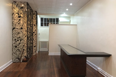Inspiration for a mid-sized timeless built-in desk dark wood floor craft room remodel in New York with beige walls