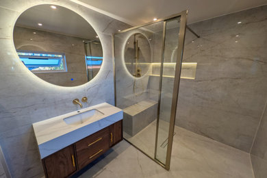 Example of a large minimalist master beige tile and ceramic tile ceramic tile, beige floor and single-sink shower bench design in London with a wall-mount toilet, beige walls, a drop-in sink, quartz countertops, white countertops and a floating vanity