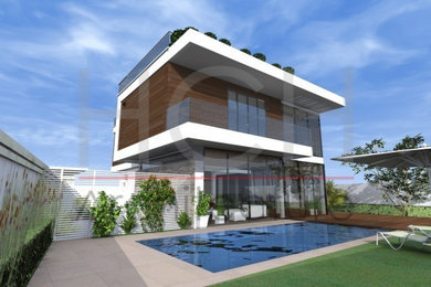 Diseño de fachada de casa actual de tres plantas con revestimientos combinados, tejado plano y tejado de varios materiales