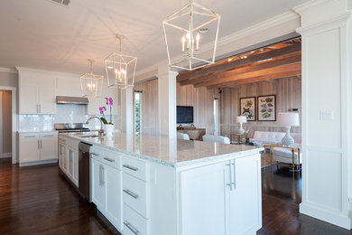 Example of a large eclectic u-shaped medium tone wood floor and brown floor enclosed kitchen design in New York with an undermount sink, shaker cabinets, white cabinets, quartz countertops, white backsplash, subway tile backsplash, stainless steel appliances and an island