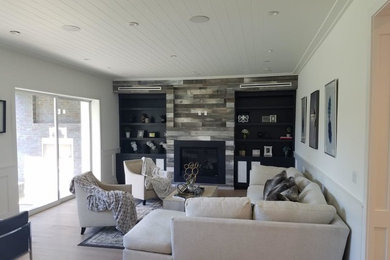 Photo of a mid-sized transitional formal open concept living room in Los Angeles with white walls, light hardwood floors, a standard fireplace, a tile fireplace surround, no tv and beige floor.