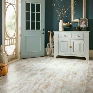 クリーブランドの大きい片開きドアカントリー風おしゃれな玄関ロビー (緑の壁、淡色無垢フローリング、青いドア、茶色い床) の写真