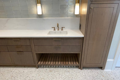 Inspiration pour une grande salle de bain principale traditionnelle en bois brun avec un placard à porte plane, une baignoire indépendante, un carrelage bleu, un carrelage en pâte de verre, un sol en terrazzo, un plan de toilette en quartz, un plan de toilette blanc, meuble simple vasque et meuble-lavabo encastré.