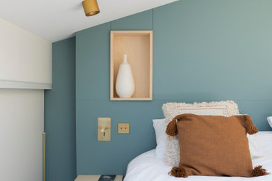 Idée de décoration pour une grande chambre parentale design avec un mur bleu, sol en béton ciré et un sol beige.
