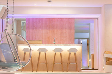Aménagement d'un bar de salon linéaire contemporain en bois clair de taille moyenne avec un placard à porte plane, plan de travail en marbre, un sol beige et un plan de travail gris.