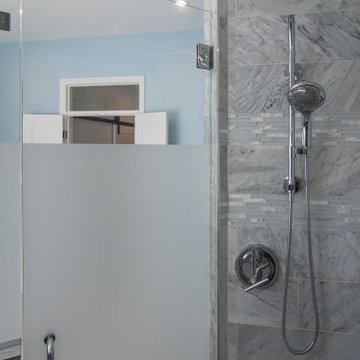 Traditional master bath utilizing frosted and clear glass to allow for needed pr