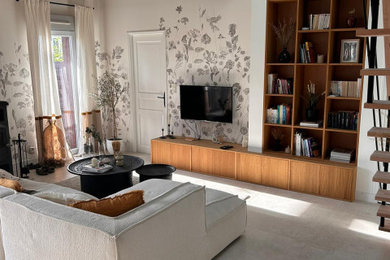 Cette image montre un salon blanc et bois ouvert avec un poêle à bois, un téléviseur fixé au mur et un escalier.