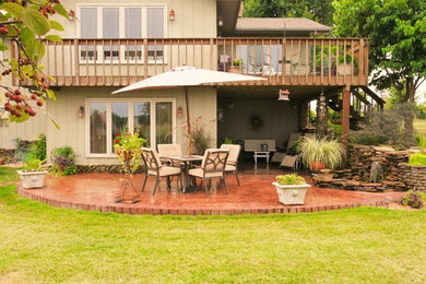 Patio fountain - large rustic backyard stamped concrete patio fountain idea in Other with a roof extension