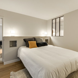 Diseño de dormitorio principal, actual, de tamaño medio, sin chimenea, con paredes grises y suelo de madera clara