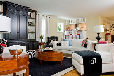 Living room - mid-sized traditional formal and open concept medium tone wood floor living room idea in Boston with beige walls, no fireplace and a concealed tv