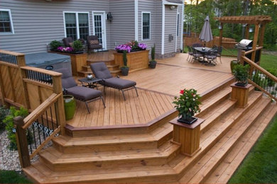 Diseño de terraza planta baja de estilo americano de tamaño medio en patio trasero con jardín de macetas, toldo y barandilla de varios materiales