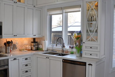 Large elegant u-shaped porcelain tile eat-in kitchen photo in Toronto with a double-bowl sink, shaker cabinets, distressed cabinets, quartz countertops, beige backsplash, stone tile backsplash, stainless steel appliances and no island