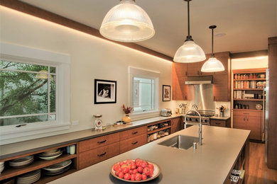 Enclosed kitchen - mid-sized transitional l-shaped medium tone wood floor and brown floor enclosed kitchen idea in San Francisco with an undermount sink, flat-panel cabinets, medium tone wood cabinets, solid surface countertops, stainless steel appliances, an island and gray countertops