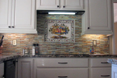 Photo of a transitional kitchen in San Diego with white cabinets, granite benchtops, multi-coloured splashback, matchstick tile splashback, stainless steel appliances and with island.