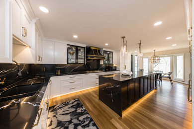 Large transitional u-shaped light wood floor and multicolored floor eat-in kitchen photo in Columbus with a double-bowl sink, recessed-panel cabinets, white cabinets, quartz countertops, black backsplash, quartz backsplash, paneled appliances, an island and black countertops
