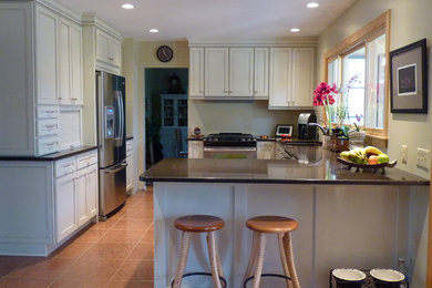 Inspiration for a large transitional u-shaped ceramic tile and brown floor eat-in kitchen remodel in Philadelphia with an undermount sink, recessed-panel cabinets, white cabinets, quartz countertops, beige backsplash and stainless steel appliances