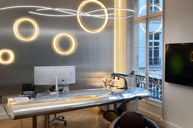 This is an example of a large contemporary study in Paris with white walls and a freestanding desk.
