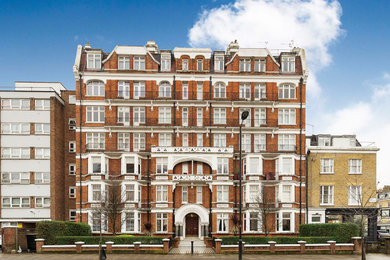 Dreistöckiges Modernes Haus mit Backsteinfassade, roter Fassadenfarbe, Walmdach und Misch-Dachdeckung in London