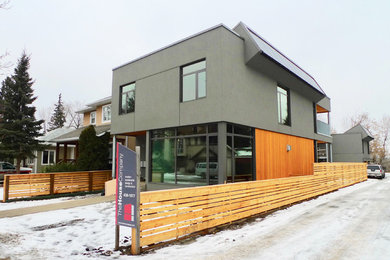 Diseño de fachada de casa gris contemporánea de dos plantas con revestimiento de estuco, tejado plano y tejado de varios materiales