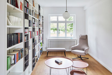 Photo of a contemporary family room in Cologne with a library.