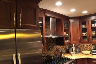 Mid-sized arts and crafts u-shaped medium tone wood floor eat-in kitchen photo in Philadelphia with an undermount sink, shaker cabinets, medium tone wood cabinets, granite countertops, multicolored backsplash, mosaic tile backsplash, stainless steel appliances and a peninsula