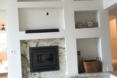 Living room - light wood floor living room idea in Other with white walls, a standard fireplace and a stone fireplace