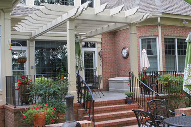 Example of a mid-sized minimalist backyard patio design in Other with a pergola