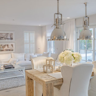 This is an example of a mid-sized traditional open plan dining in Munich with white walls and light hardwood floors.