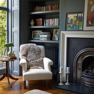 Modelo de despacho tradicional con paredes azules, suelo de madera en tonos medios y chimenea tradicional