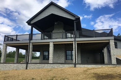 Example of a backyard deck design in Other with a fire pit and a roof extension