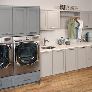 Design ideas for a medium sized traditional single-wall separated utility room in Seattle with a submerged sink, recessed-panel cabinets, grey cabinets, composite countertops, grey walls, dark hardwood flooring, a side by side washer and dryer and brown floors.