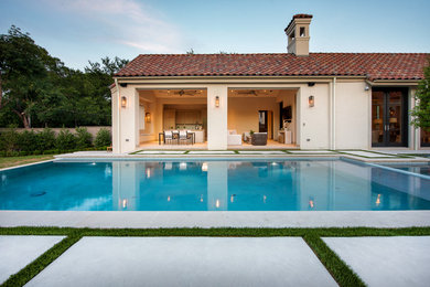 This is an example of a large mediterranean concrete paver screened-in back porch design in Dallas with a roof extension.