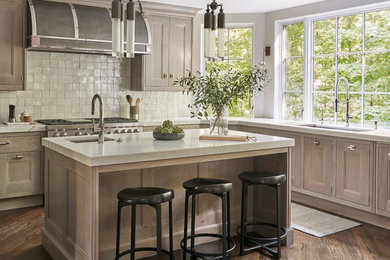 This is an example of a transitional u-shaped kitchen in Chicago with an undermount sink, beaded inset cabinets, beige cabinets, dark hardwood floors, with island, brown floor and grey benchtop.