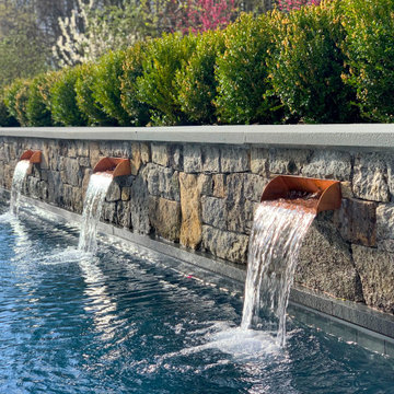Swimming Pool With Stone Wall And Water Feature
