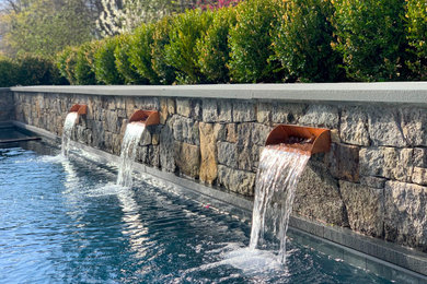 Example of a large classic backyard stone and rectangular lap pool landscaping design in New York