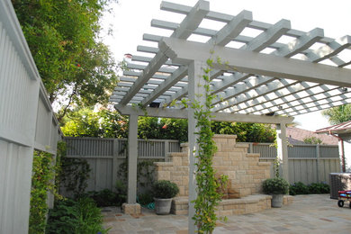 Mid-sized elegant backyard patio fountain photo in Santa Barbara with a pergola